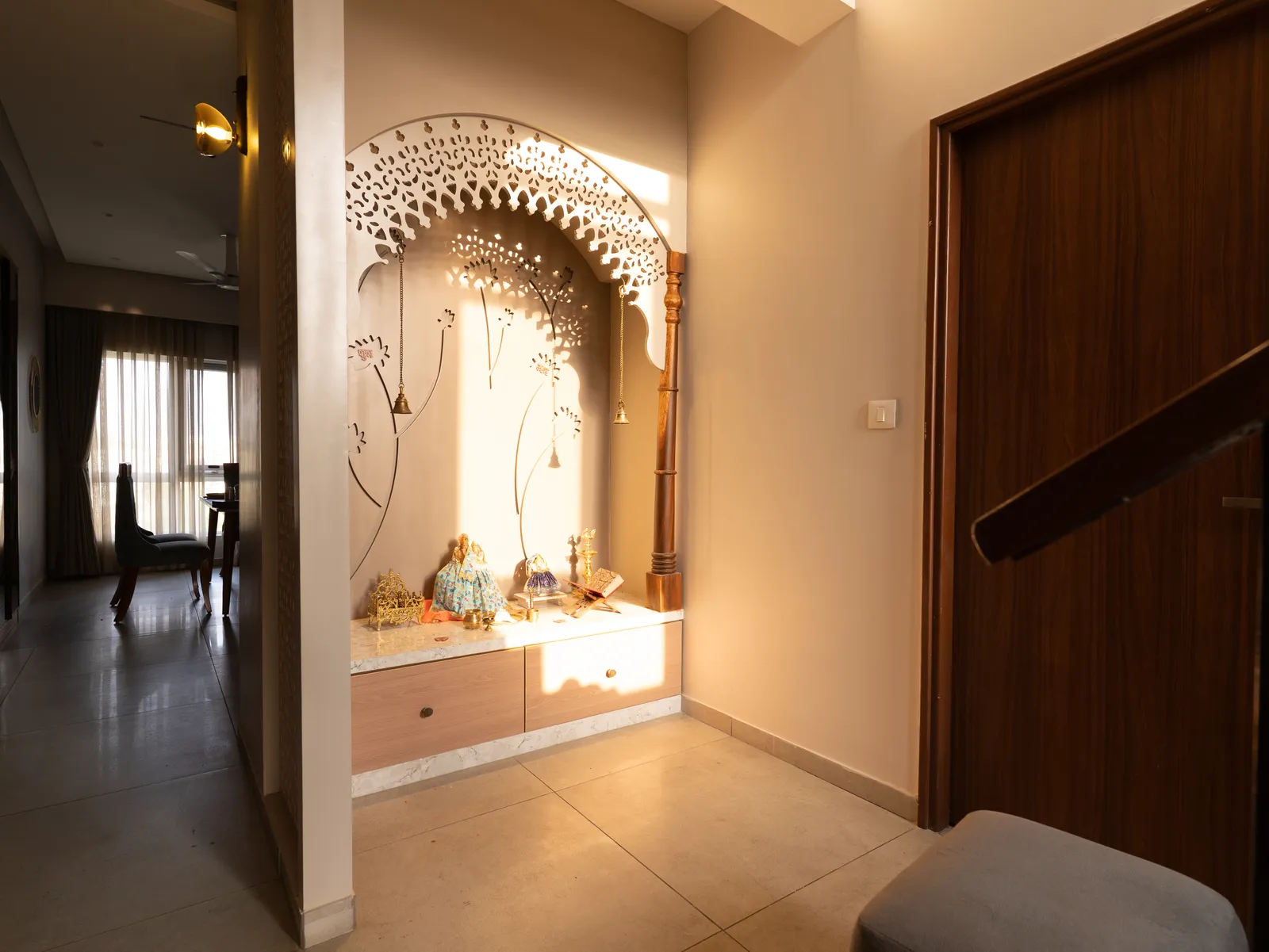 Pooja unit with carved arch in the hallway — Amlan's Residence